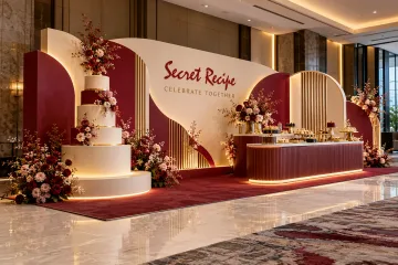 Secret Recipe anniversary celebration with tiered cake display, curved birthday panels and elegant dessert counter