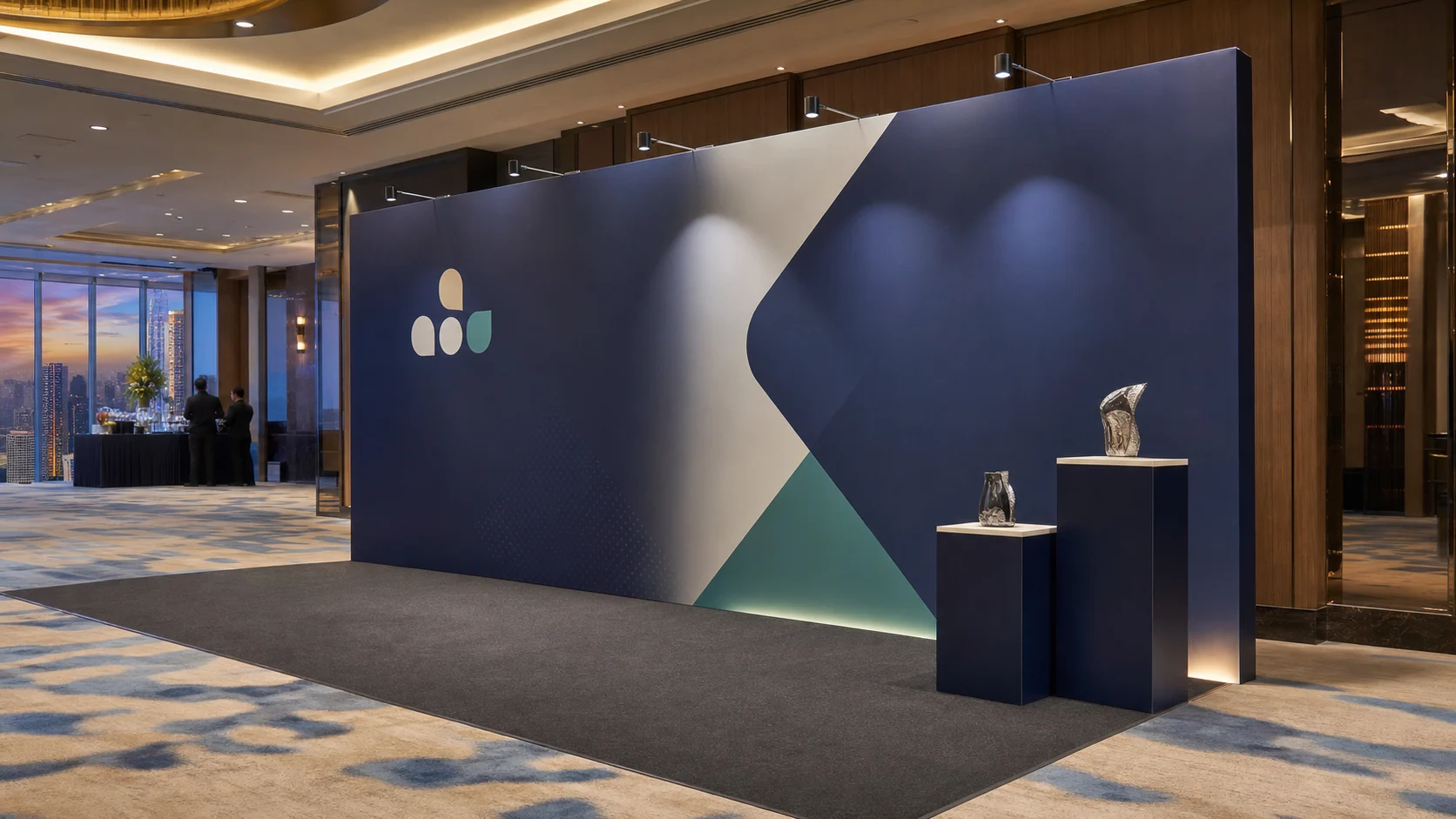 Navy corporate media-launch backdrop concept with product plinths in a Kuala Lumpur hotel ballroom